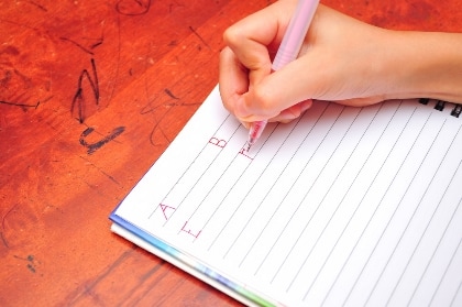Как научить ребенка писать прописью - детская рука аккуратно выводит буквы в тетради